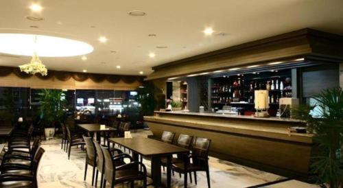 a restaurant with tables and chairs and a bar at Metro Tourist Hotel Cheonan in Cheonan