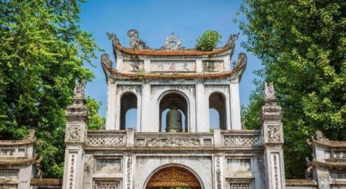 a building with a tower in the middle of trees at Ha Noi Vang Hotel Hoang Ngan in Hanoi