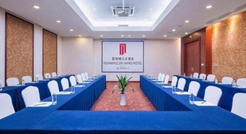 a conference room with blue tables and white chairs at Kunming Jinjiang Hotel in Kunming