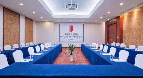 a conference room with blue tables and white chairs at Kunming Jinjiang Hotel in Kunming