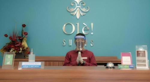 a man standing behind a counter with a mask on his face at Ole Suite Hotel in Bogor