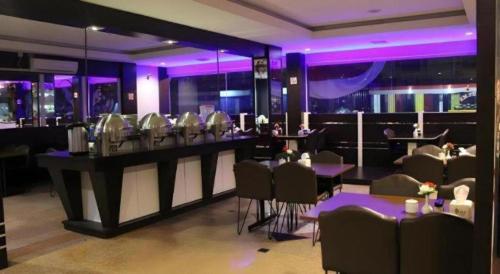 a restaurant with a bar with chairs and purple lighting at Balai View Hotel in Tanjung Balai Karimun
