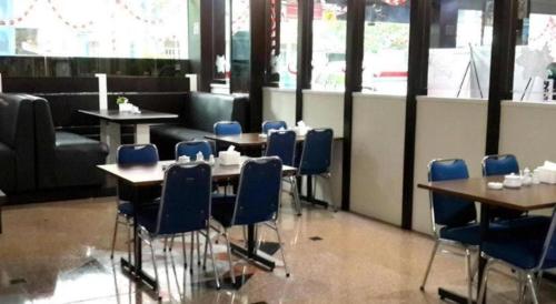 a dining room with blue chairs and tables in a restaurant at Balai View Hotel in Tanjung Balai Karimun
