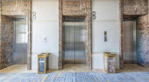 a lobby with three elevators in a building at Yanji Yanbian International Hotel in Yanji