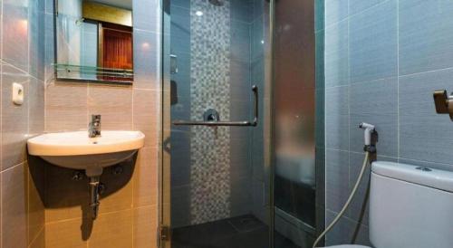 a bathroom with a sink and a shower and a toilet at Hadi Poetra Hotel in Kuta