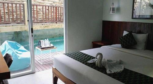 a bedroom with a bed with a swan on it at Hadi Poetra Hotel in Kuta