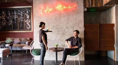 a man and a woman sitting in chairs in a room at Hadi Poetra Hotel in Kuta