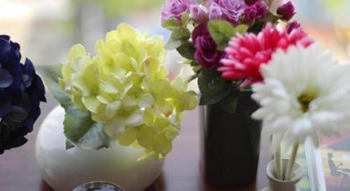 a group of flowers in a white vase on a table at Huong Binh Hotel in Da Nang