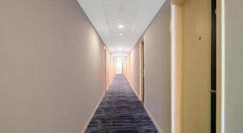 a hallway with a long corridor with a carpet on the floor at Jinjiang Inn Quanzhou West Street Kaiyuan Temple in Quanzhou