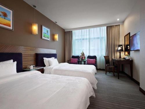 a hotel room with two beds and a desk at Shenzhen Hanyong Hotel Fuyong Branch in Shenzhen