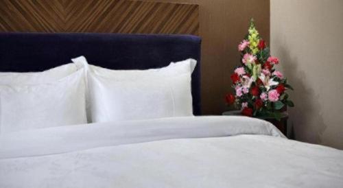 a bed with pillows and a christmas tree in a room at Shenzhen Hanyong Hotel Fuyong Branch in Shenzhen