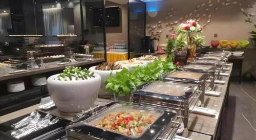 a buffet line of food in a restaurant at Shenzhen Hanyong Hotel Fuyong Branch in Shenzhen