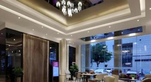 a dining room with a ceiling with a chandelier at Shenzhen Hanyong Hotel Fuyong Branch in Shenzhen