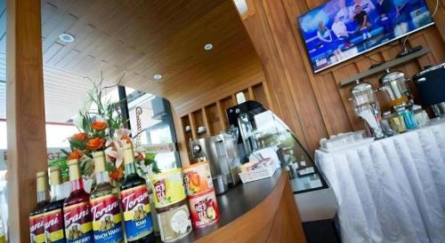a restaurant with a bar with a counter with drinks at GT Residence Hotel in Buriram