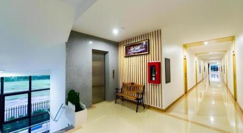 a hallway with a bench and a view of the ocean at GT Residence Hotel in Buriram