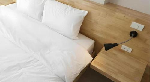a bedroom with a bed with a phone next to it at Esy Hotel in Lamphun
