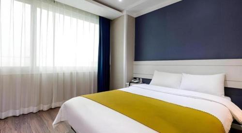 a bedroom with a large bed and a window at Galaxy Hotel in Jeju