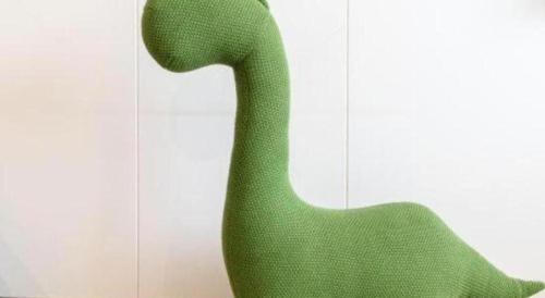 a green chair sitting next to a wall at SUN Yat-sen university Hotel and Conference Centre in Guangzhou