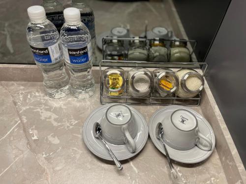 un comptoir avec deux assiettes et des bouteilles d'eau et des gobelets d'eau dans l'établissement Deluxe Room Sea View Pool Golf Nuvasa Bay Kalani Tower, à Pulau Nongsa