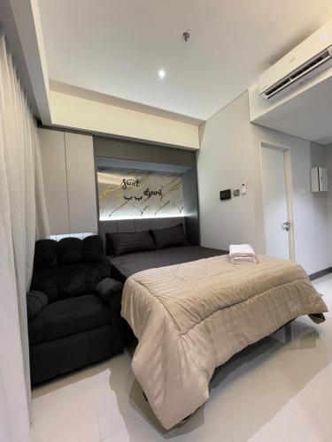 une chambre avec un lit et un canapé dans l'établissement Deluxe Room Sea View Pool Golf Nuvasa Bay Kalani Tower, à Pulau Nongsa