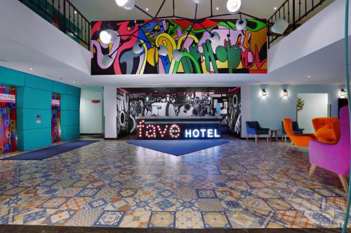 a hotel lobby with a colorful mural on the wall at favehotel Kuta Kartika Plaza in Kuta