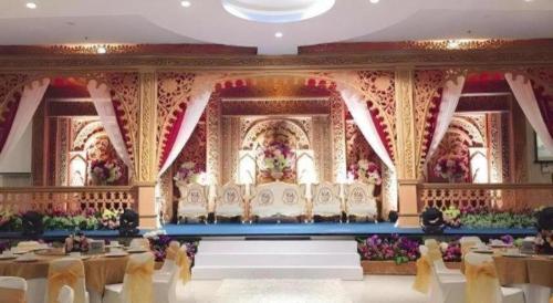 a banquet hall with tables and chairs and flowers at CK Tanjungpinang Hotel and Convention Centre in Tanjung Pinang 