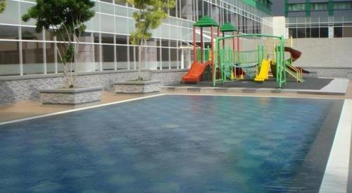 a pool with a slide and a playground in a building at CK Tanjungpinang Hotel and Convention Centre in Tanjung Pinang 