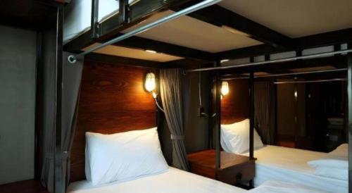 a bedroom with two bunk beds and a mirror at Rider bedroom hostel & cafe in Hua Hin