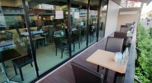a restaurant with a table and chairs and windows at Wsotel Hotel in Songkhla