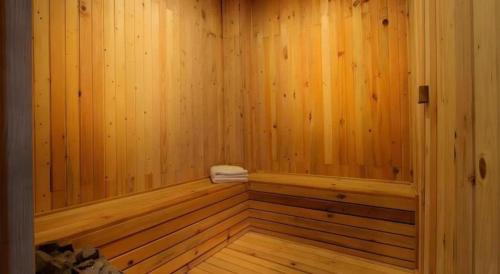 a wooden sauna with a towel sitting in it at Umah Bali Suites in Denpasar