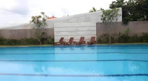 a group of chairs sitting next to a swimming pool at Umah Bali Suites in Denpasar