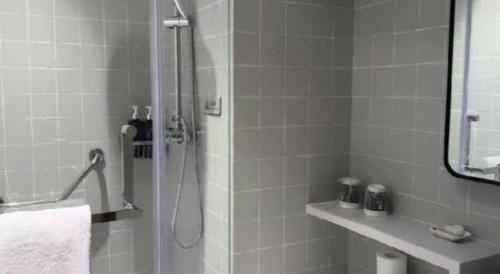 a bathroom with a shower with a sink and a mirror at Magnotel Shanghai Henglong Plaza in Shanghai