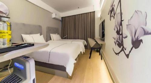 a hotel room with a bed and a desk with a laptop at Magnotel Shanghai Henglong Plaza in Shanghai