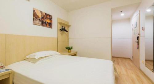 a bedroom with a large white bed in a room at Magnotel Shanghai Henglong Plaza in Shanghai