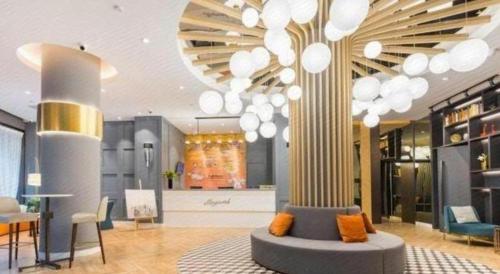 a lobby with a couch in the middle of a building at Magnotel Shanghai Henglong Plaza in Shanghai