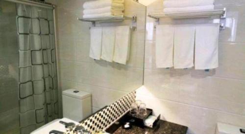 a bathroom with a sink and a toilet and towels at Gui Feng Hotel in Jiangmen