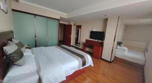a hotel room with a large bed and a television at GreenTree Inn Luoyang Zhongzheng Street Express Hotel in Luoyang