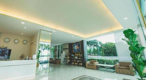 a large living room with chairs and a large window at Phuglong Hotel in Phayao
