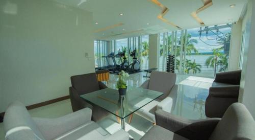 a living room with a glass table and chairs at Phuglong Hotel in Phayao