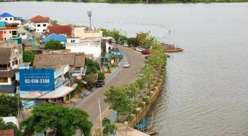 a town next to a body of water with houses at Phuglong Hotel in Phayao