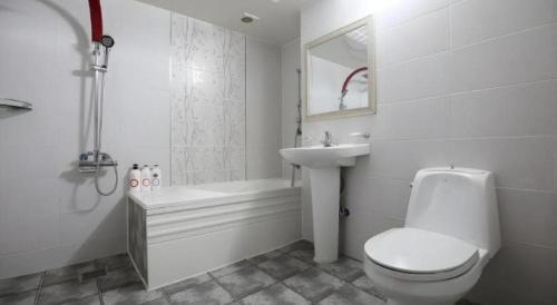 a white bathroom with a toilet and a sink at Hotel Primo Daejeon in Daejeon