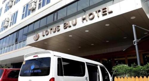a white van parked in front of a building at Lotus Blu Hotel in Legazpi
