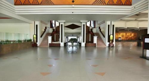 an empty lobby of a building with a staircase at Hotel Niagara Parapat in Parapat