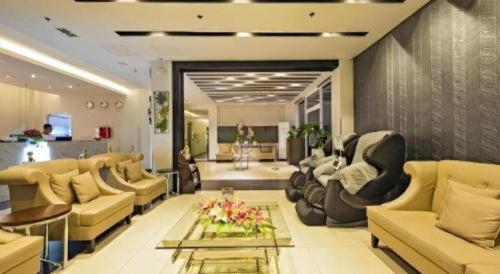 a lobby with couches and chairs and a table at Eighty Eight Hotel in Koronadal