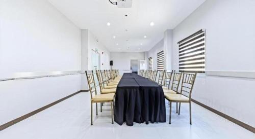 a dining room with a black table and chairs at Eighty Eight Hotel in Koronadal