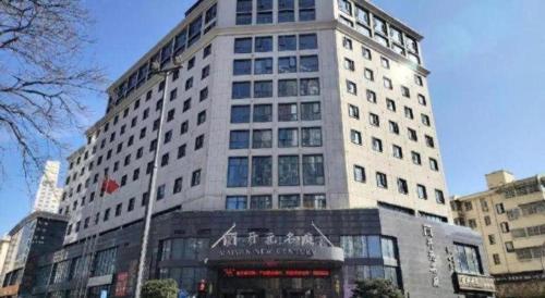a tall white building with a sign in front of it at New Century Kylie Hotel Ningbo in Ningbo