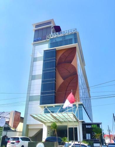 a building with a sign on the side of it at Java Lotus Hotel Jember in Jember