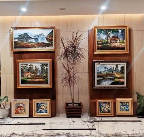 a group of pictures on a wall in a room at Java Lotus Hotel Jember in Jember