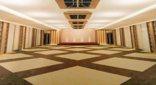 an empty room with a checkered floor at Java Lotus Hotel Jember in Jember