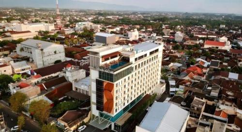 an overhead view of a city with a tall building at Java Lotus Hotel Jember in Jember